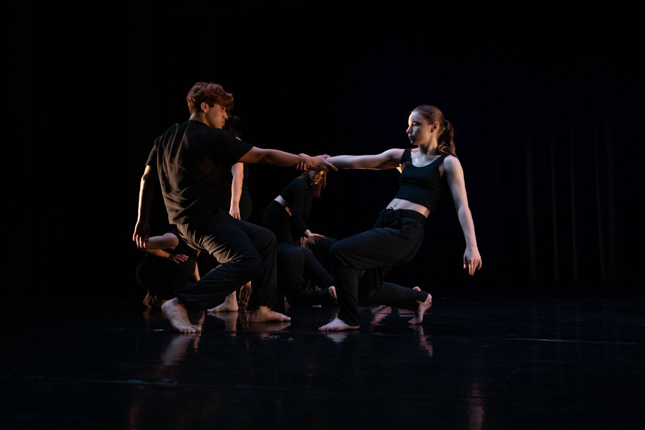 Students dancing wearing all black.