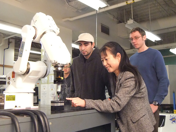 Professor and two student working on a mechanical engineering project.