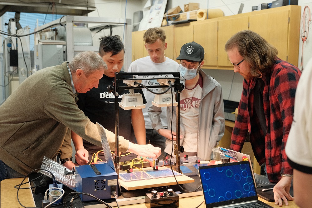 students & professor working on solar lab