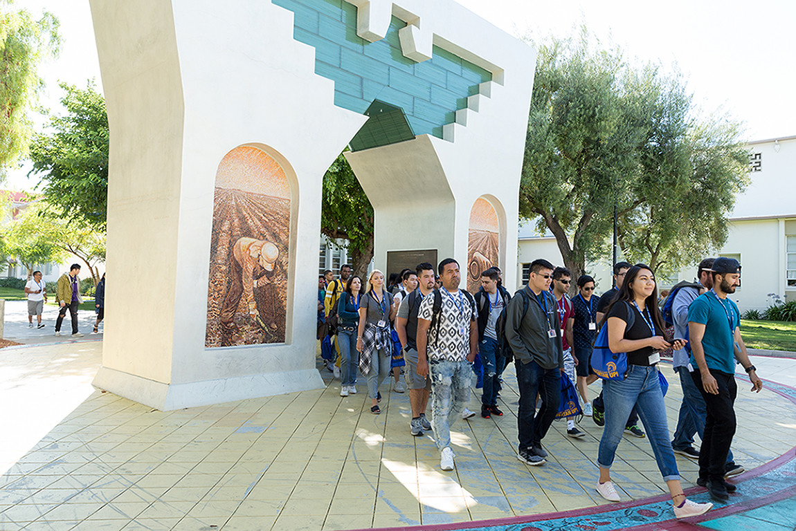 Student walking under Cesar Chavez Arch