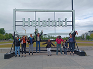 photo of Finland group jumping in front of Helsinski sign