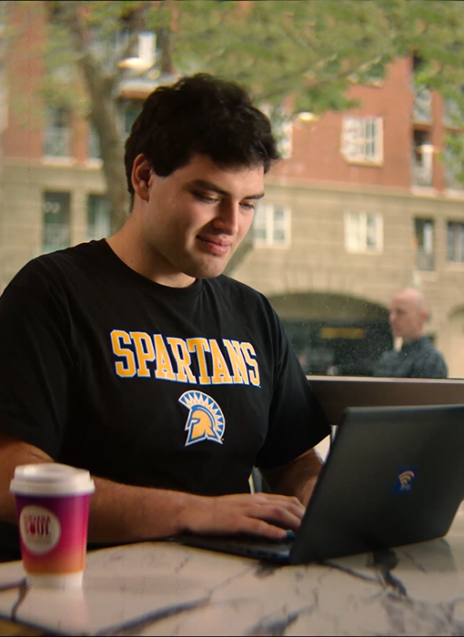 SJSU student studying on laptop at a cafe