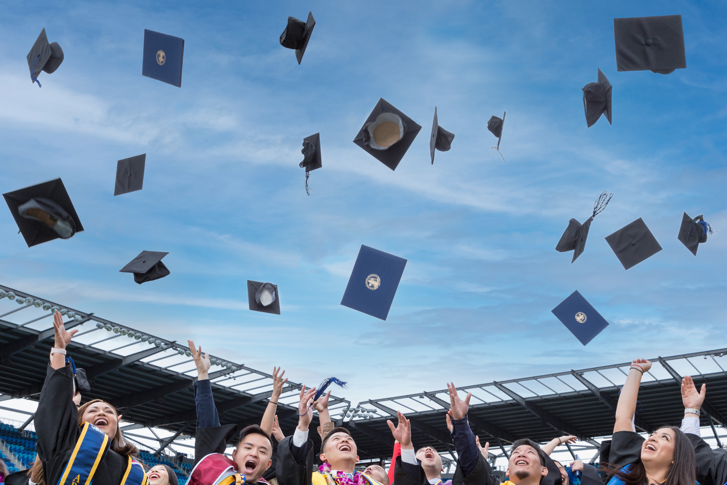 SJSU graduates throwing their caps in the air