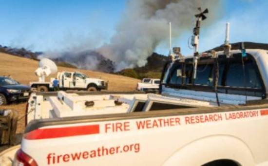 wildfire interdisciplinary research center truck with advanced equipment sits in front of burning ridge