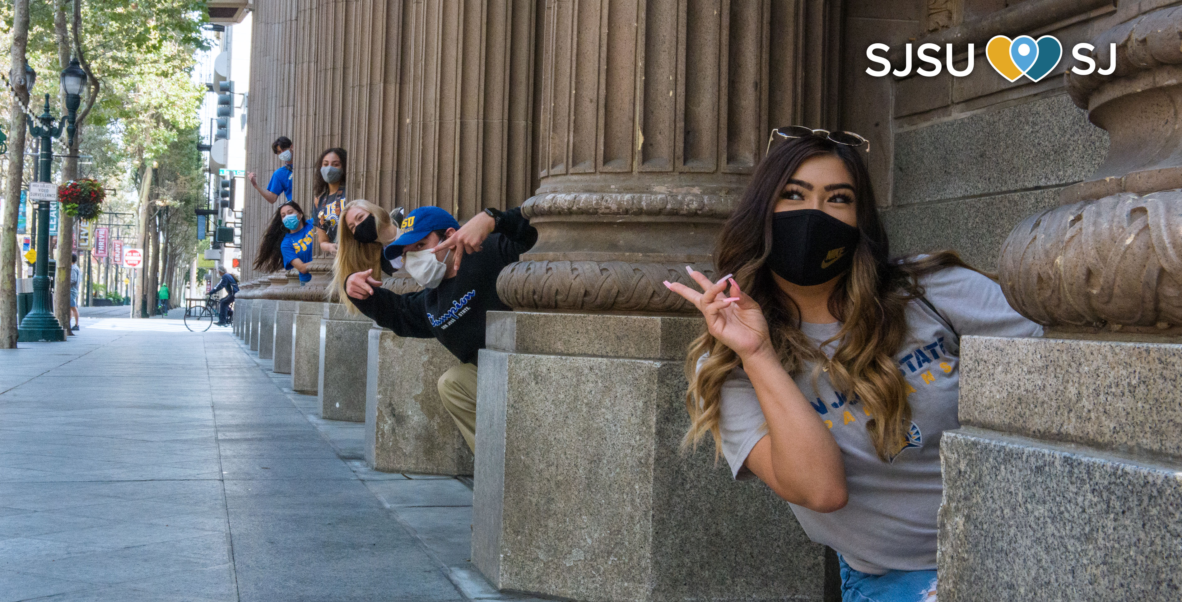 SJSU students pose behind pillars in downtown San Jose.