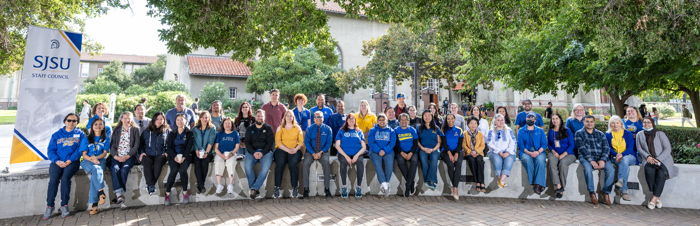 SJSU Staff Council members are sitting together in the Bell Rose Garden.