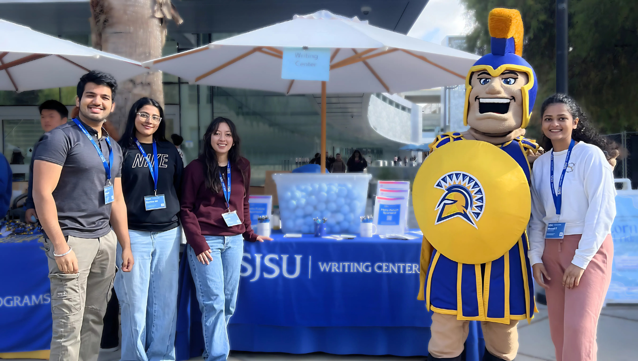 Team members standing in front of table with Sammy Spartan